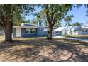 A quaint single-story home with a covered parking area and mature trees at 1006 San Domingo Rd, Orlando, FL 32808