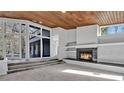 Living room boasting a warm fireplace, wood ceiling and wall of windows for natural light at 104 Wild Plum Ln, Longwood, FL 32779