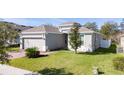 Charming single-Gathering home featuring a well-maintained lawn, brick driveway, and two-car garage at 1097 Hendon Loop, Davenport, FL 33837