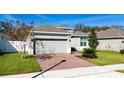 Charming single-Gathering home featuring a well-maintained lawn, brick driveway, and two-car garage at 1097 Hendon Loop, Davenport, FL 33837