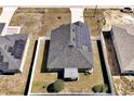 An aerial view of a fenced home with a solar panel roof and landscaping at 1238 James Ln, Kissimmee, FL 34759