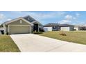 A single-story home with a long driveway and well-manicured lawn at 1238 James Ln, Kissimmee, FL 34759
