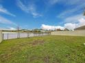 Large backyard with a fence, lawn, and lake view, perfect for outdoor enjoyment at 1524 Venice Ln, Davenport, FL 33896