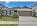 Charming single-story home featuring a two-car garage and well-manicured front yard at 1524 Venice Ln, Davenport, FL 33896