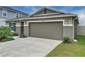 Exterior view of a home with a spacious two-car garage and a well-kept lawn at 1524 Venice Ln, Davenport, FL 33896