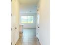 Bright foyer with tile flooring, white doors and trim, and a view into the living spaces at 1613 Pelican Dr, Davenport, FL 33896