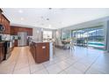 Open kitchen featuring dark wood cabinetry, granite countertops, stainless appliances, and dining area overlooking the pool at 1737 Caribbean View Ter, Kissimmee, FL 34747