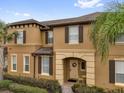 Charming two-story townhome featuring a well-manicured front yard and neutral-toned facade with decorative shutters at 2234 Calabria Ave, Davenport, FL 33897