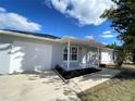 The front of this single-story house features an attractive, landscaped yard and a freshly painted exterior at 305 S Palm Ave, Kissimmee, FL 34741