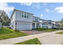 Charming two-story home boasts a brick-paved driveway, attached garage, and beautifully landscaped front yard at 3987 Meandering Bay Dr, Apopka, FL 32712