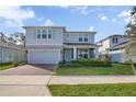 Charming two-story home boasts a brick-paved driveway, attached garage, and beautifully landscaped front yard at 3987 Meandering Bay Dr, Apopka, FL 32712