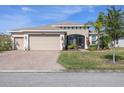 Well-maintained single-story home with a three-car garage and lush landscaping at 4311 Via Cavour Ct, Kissimmee, FL 34759