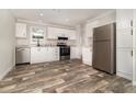 Modern kitchen with stainless steel appliances, white cabinetry, and granite countertops at 4626 Bunting Ave, Orlando, FL 32812