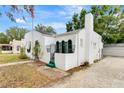 Charming white home with green trim, arched doorway, awning, flagpole, and unique textured facade at 528 S 8Th St, Lake Wales, FL 33853