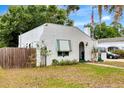 Charming white home with green trim, arched doorway, awning, flagpole, and unique textured facade at 528 S 8Th St, Lake Wales, FL 33853