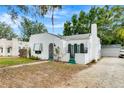 Charming white home with green trim, arched doorway, awning, flagpole, and unique textured facade at 528 S 8Th St, Lake Wales, FL 33853