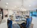 Open-concept dining area adjacent to kitchen, featuring modern lighting and seating for six at 7641 Modica St, Clermont, FL 34714