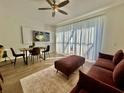 Bright living room with comfortable seating, dining table, a large window with sheer curtains, and TV at 7670 Otterspool St, Kissimmee, FL 34747