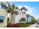 Beautiful two-story home featuring a balcony, complemented by lush landscaping and swaying palm trees at 8012 Lost Shaker Ln, Kissimmee, FL 34747