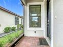 The front porch with brick flooring leads to a stylish front door and screened entrance at 806 Via Como St, Poinciana, FL 34759