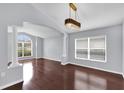 Elegant living room featuring hardwood floors, arched entryway, and stylish light fixture at 923 Tramells Trl, Kissimmee, FL 34744