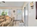 Cozy living room featuring wood floors, large windows, and a decorative glass door at 9559 Dubois Blvd, Orlando, FL 32825