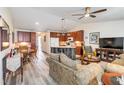 Open-concept living space with wood floors, a kitchen island, and comfortable seating at 9559 Dubois Blvd, Orlando, FL 32825