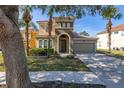 Charming two-story home with tile roof, arched entry, and well-manicured landscaping at 113 Tiger Lily Ct, Davenport, FL 33837