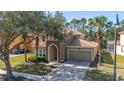 Charming two-story home with tile roof, arched entry, and well-manicured landscaping at 113 Tiger Lily Ct, Davenport, FL 33837