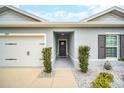 Inviting front entrance with decorative door wreath, clean landscaping, and attached garage at 1185 Catskill Dr, Haines City, FL 33844