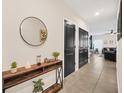 Hallway with modern console table and mirror offers a glimpse into the open-plan living area at 1185 Catskill Dr, Haines City, FL 33844