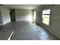 Spacious living room with tile flooring, neutral walls, and ample natural light at 1629 Ambar Ct, Winter Haven, FL 33881