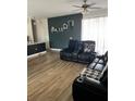 Living room with comfortable seating area, dark accent wall, and bright natural light at 1664 Redfin Dr, Kissimmee, FL 34759
