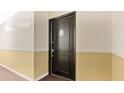 A dark-colored front door with a handle and a unit number sign, set against neutral-colored walls at 1695 Lee Rd # E103, Winter Park, FL 32789
