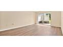 Bright living room with wood floors and sliding glass doors to a patio area at 1695 Lee Rd # E103, Winter Park, FL 32789