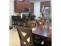 Kitchen and Dining area featuring dark wood cabinetry, stainless appliances, and a breakfast bar at 1749 Fulfillment Dr, Kissimmee, FL 34744