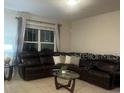 Comfortable living room with a large sectional sofa, stylish coffee table, and natural light at 1749 Fulfillment Dr, Kissimmee, FL 34744