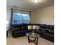 Comfortable living room with a large sectional sofa, stylish coffee table, and natural light at 1749 Fulfillment Dr, Kissimmee, FL 34744