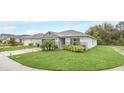 Single-story home with a lush green lawn, and a two-car garage, set in a quiet neighborhood at 1877 River Crest Ave, St Cloud, FL 34771