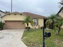 Charming single-story home featuring a two-car garage and tropical landscaping at 217 Sand Ridge Dr, Davenport, FL 33896