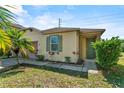 Lovely one-story home with green trim, beige siding, green door, and green tropical landscaping at 217 Sand Ridge Dr, Davenport, FL 33896
