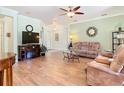 Cozy living room with wood floors, a ceiling fan, and a comfortable seating arrangement at 400 Indian Wells Ave, Poinciana, FL 34759
