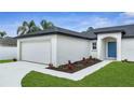 A charming home featuring a two-car garage and vibrant, colorful landscaping at 41 Peterlee Ct, Kissimmee, FL 34758