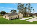 An elevated view of a home with a lush lawn and a long driveway leading to the garage at 43 Peterlee Ct, Kissimmee, FL 34758