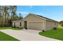 A sunny home with an attached two-car garage and long concrete driveway at 43 Peterlee Ct, Kissimmee, FL 34758