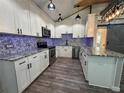 Modern kitchen featuring white cabinets, stainless steel appliances, and eye-catching backsplash and countertops at 430 Connecticut Ave, St Cloud, FL 34769