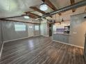 Open-concept living room with exposed beams, modern lighting fixtures and a kitchen bar with stainless steel appliances at 430 Connecticut Ave, St Cloud, FL 34769