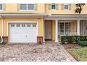 Townhome featuring a two-car garage, and inviting front door at 4925 Poolside, St Cloud, FL 34769