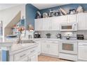 Bright kitchen with white cabinets, marble countertops, and stainless steel appliances at 4925 Poolside, St Cloud, FL 34769