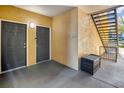 Condo entrance with two gray doors, stairs, and seating area at 6153 Metrowest Blvd # 103, Orlando, FL 32835